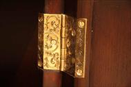 Engraved brass hinges on a ebony door