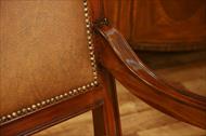 Leather upholstered mahogany dining chairs with brass nail trim