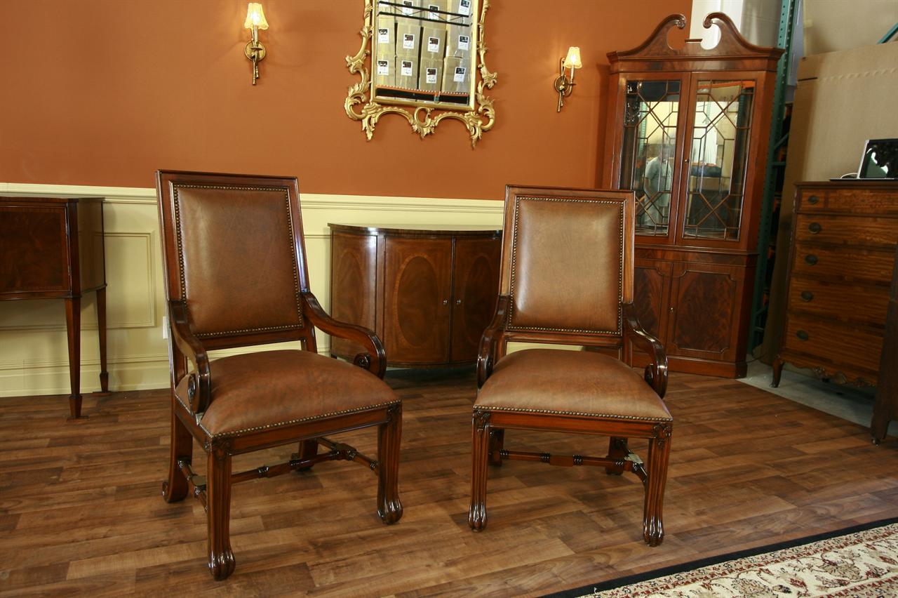 Leather upholstered mahogany dining chairs with brass nail trim