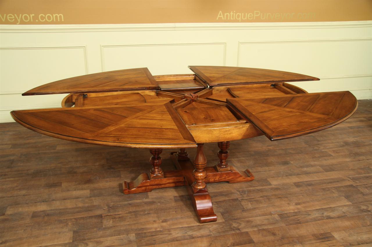 Large Oval solid walnut dining table with hidden leaves opens to larger