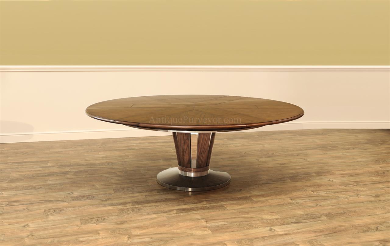 Modern round to round jupe style dining table with brass accented pedestal. Solid walnut dining table with self-storing leaves.