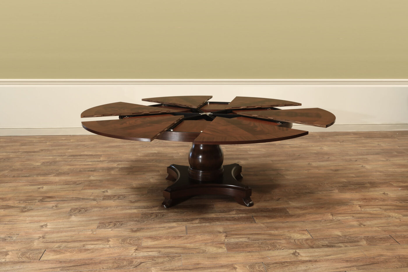Mahogany Jupe table.  64 inch round to round solid dining table with brown mahogany finish. Leaves are self storing and fold out to make a larger 84 inch round dining table. - Image 5