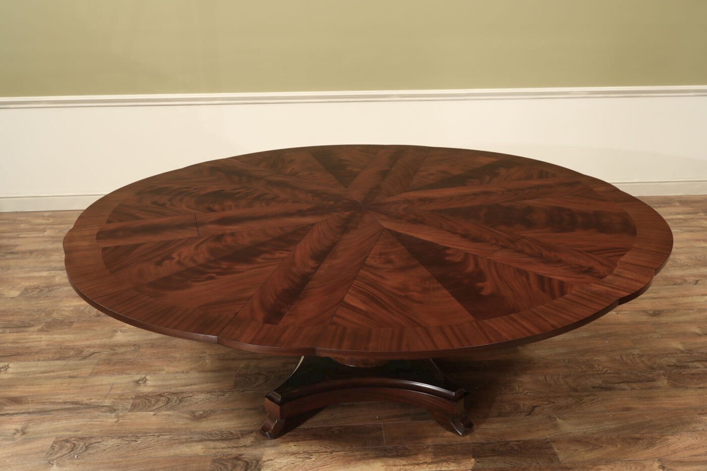 Mahogany Jupe table.  64 inch round to round solid dining table with brown mahogany finish. Leaves are self storing and fold out to make a larger 84 inch round dining table. - Image 4