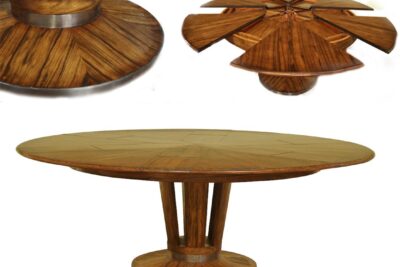 Modern round to round jupe style dining table with brass accented pedestal. Solid walnut dining table with self-storing leaves.