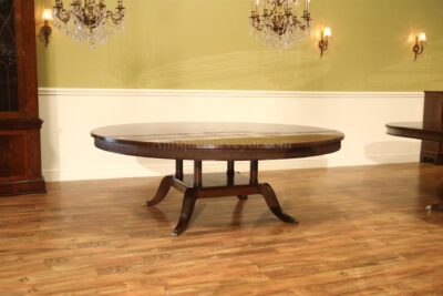Extra large 84 inch American made mahogany dining room table with feather carved apron and sturdy birdcage pedestal