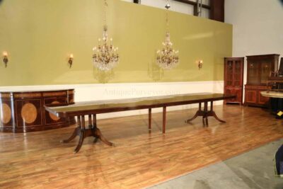 Extra large mahogany dining table, finished in the USA. A fine inlaid antique reproduction dining table with triple birdcage style pedestals.