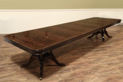 Large 14 foot banquet table finished in the USA. Narrow and long inlaid mahogany dining table. Sits on birdcage style pedestals