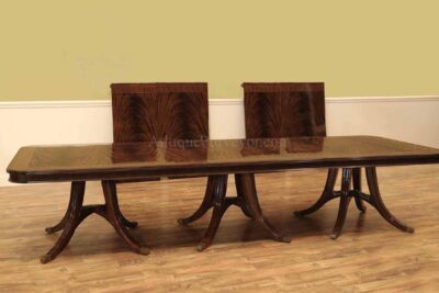 Large expanding mahogany dining room table with transitional saber leg pedestals