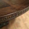 Round rustic dining table with walnut finish and robust base. - Image 4