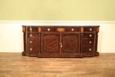 Large sideboard buffet or credenza with brass and ebony inlays.  Break bowfront with graduated drawers